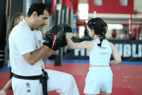 A girl training in martial arts with her coach